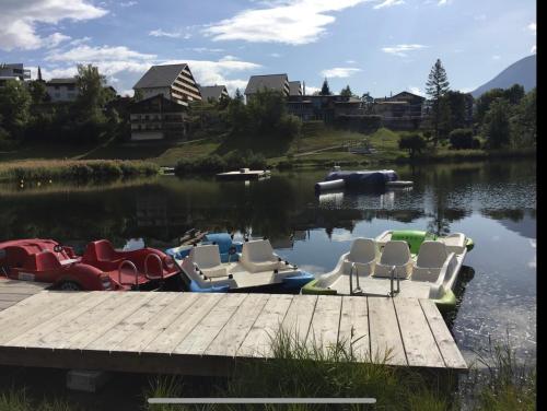 a group of chairs sitting on a dock on a lake at Crap da Flem - 3.5 Zimmer Ferienwohnung am Sonnenhang von Flims in Flims