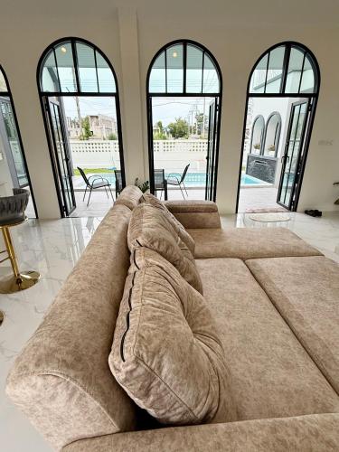 a large couch in a living room with windows at N&C Mountain Pool Villa Huahin in Hua Hin
