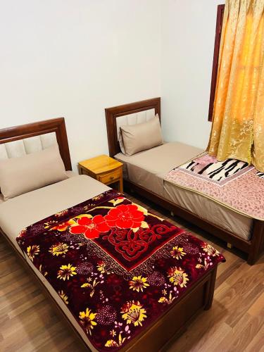 two beds sitting next to each other in a room at Hagounia hotel in Tan-Tan
