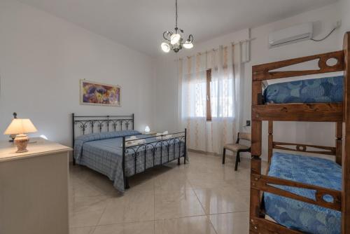 una camera con due letti a castello e una scrivania di Villetta al mare a Marina di Mancaversa