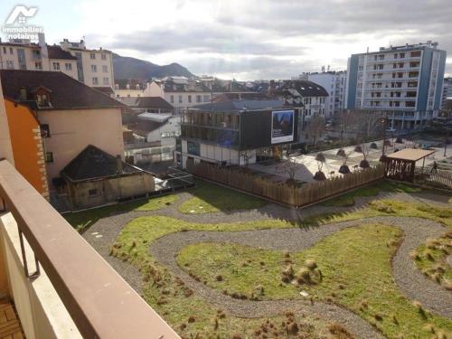 - une vue sur un jardin dans une ville avec des bâtiments dans l'établissement T3 Centre ville & Lac, Balcon, Garage, à Annecy