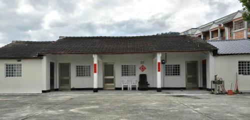 a white building with two chairs in front of it at Qitai B&B in Luye