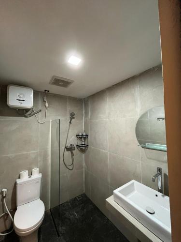 a bathroom with a shower and a toilet and a sink at Alzeto Coliving in Legian