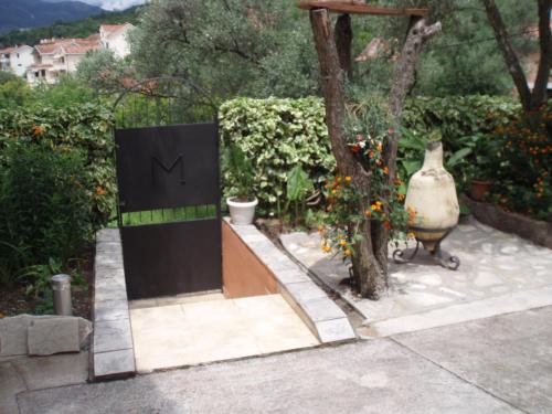 a door with a sign on it in a garden at M Group studio in Tivat