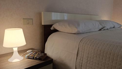 a bedroom with a bed with a lamp and a remote control at casApulia in Conversano