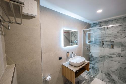 a bathroom with a sink and a shower at Ermes Luxury Hotel in Durrës