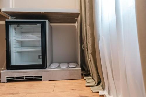 a television sitting in a refrigerator next to a window at Ermes Luxury Hotel in Durrës