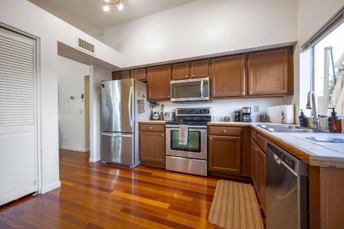 a kitchen with wooden cabinets and stainless steel appliances at Desert View Home Pool & Hot Tub in Phoenix