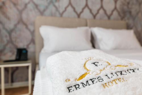 a bed with a white blanket on top of it at Ermes Luxury Hotel in Durrës