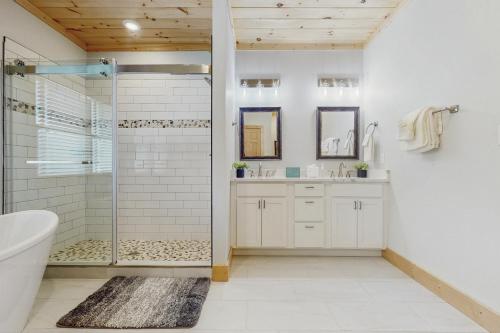 a white bathroom with a shower and a sink at Sweet Retreat in Sevierville