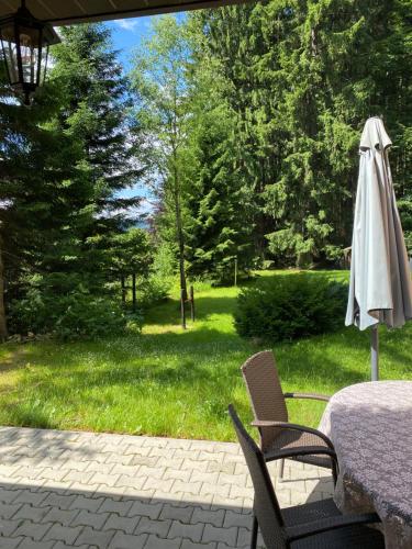 an umbrella sitting next to a table and chairs at Alba Apartmany Železná Ruda in Železná Ruda