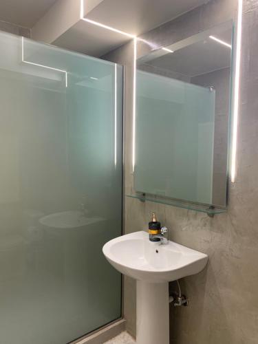 a bathroom with a sink and a shower with a mirror at SouSouLa Garden in Kavala