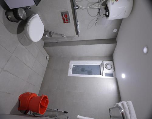 a bathroom with a red towel dispenser on the wall at Hotel Royal Galaxy Blest Park in New Delhi
