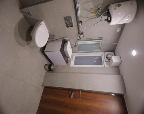 an overhead view of a small bathroom with a toilet and sink at Hotel Royal Galaxy Blest Park in New Delhi