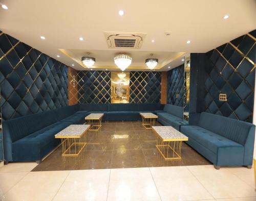 a waiting room with blue couches and tables at Hotel Royal Galaxy Blest Park in New Delhi
