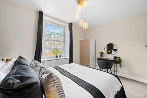 a bedroom with a bed and a table and a window at New! - The Most Central and Lux Whitby House - Hot-Tub in Whitby