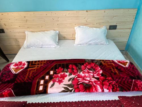 a bed with two pillows and a blanket on it at Ganga Valley Homestay in Chakrāta