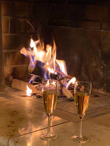 two glasses of wine in front of a fireplace at Crap da Flem - 3.5 Zimmer Ferienwohnung am Sonnenhang von Flims in Flims