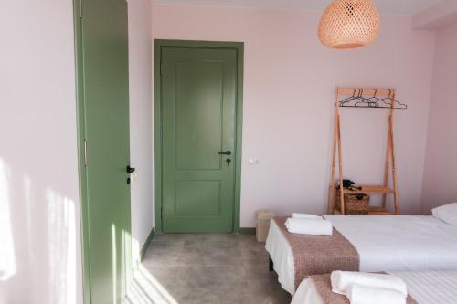a green door in a room with two beds at Limonura in Tsikhisdziri