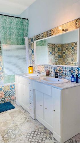a bathroom with two sinks and a large window at Villa cosy in Fumel