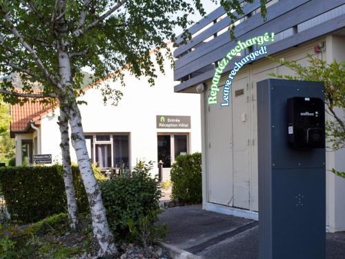 a parking meter in front of a building at Campanile Millau in Millau