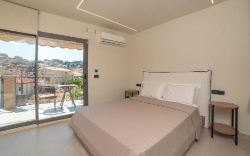 a bedroom with a bed and a large window at Baywatch LUXURY BOUTIQUE in Parga
