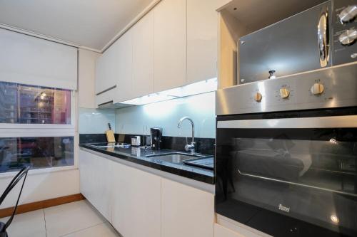 a kitchen with a stove and a sink at Delightful Studio Apartment in Las Condes in Santiago
