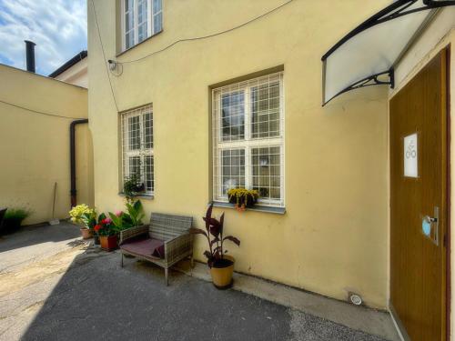 a yellow building with a bench and some plants at Penzion U Hradeb in Znojmo