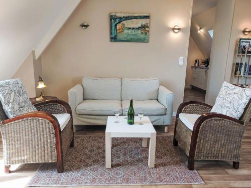 un salon avec un canapé, deux chaises et une table dans l'établissement Apartment La Note Bleue by Interhome, à Cancale