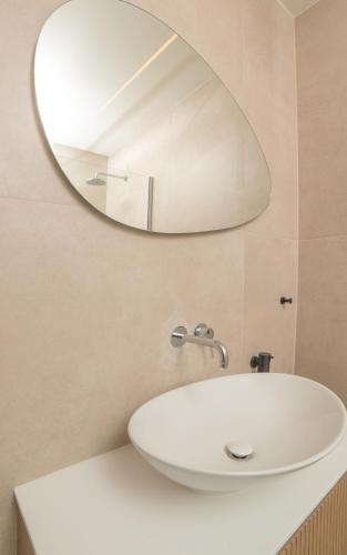 a bathroom with a white sink and a mirror at Baywatch LUXURY BOUTIQUE in Parga