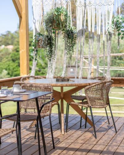 a wooden table and chairs on a deck with crystals at Résidence Casarina in Bonifacio