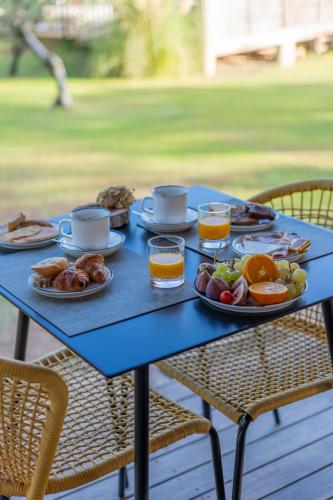 a blue table topped with plates of food and drinks at Résidence Casarina in Bonifacio