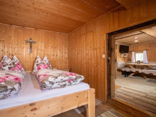a wooden room with a bed and a cross on the wall at Holiday Home Hochzillertalblick by Interhome in Gattererberg