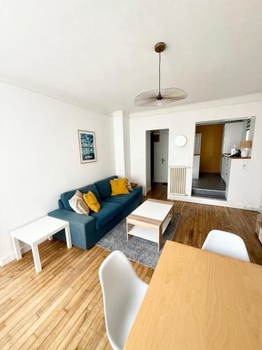 un salon avec un canapé bleu et une table dans l'établissement Appartement avec chambre séparée Brest centre ville, à Brest