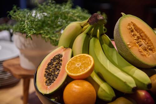 a bowl of fruit with bananas oranges and other fruits at X Hotel in Skjetten
