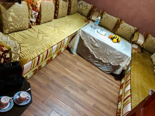 a room with a couch with a table on it at Hagounia hotel in Tan-Tan
