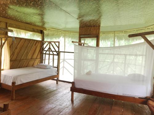 Ένα ή περισσότερα κρεβάτια σε δωμάτιο στο CAMUNGO jungle Lodge in indigenous community ALL INCLUSIVE