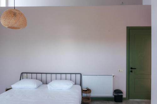a bedroom with a bed and a green door at Limonura in Tsikhisdziri