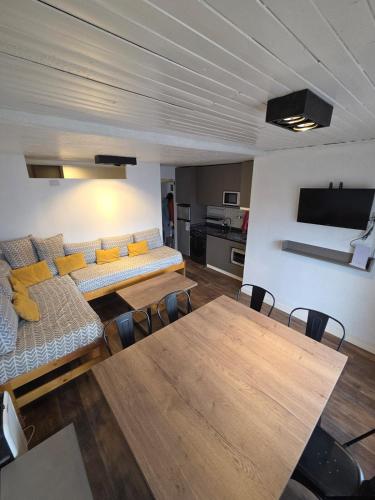 een woonkamer met een bank en een tafel bij Recién renovado, 2 habitaciones, 1 baño in Las Lenas