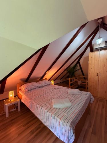 a bedroom with a large bed in a attic at Gučevska Idila in Loznica