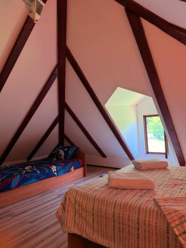 a attic room with two beds and a window at Gučevska Idila in Loznica
