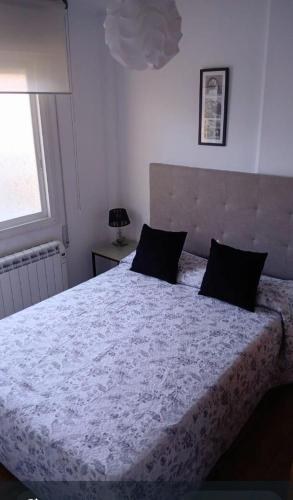 a bedroom with a large bed with a white comforter at Enseñanza in Ourense