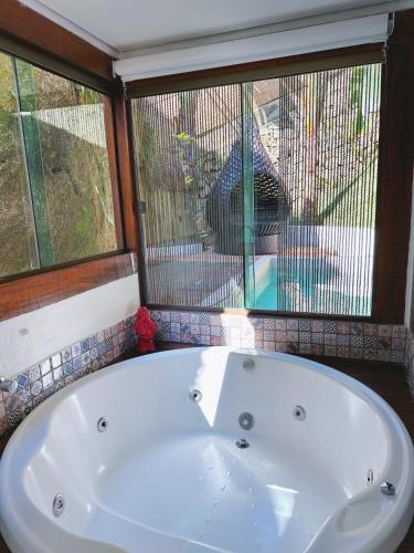 a white bath tub in a room with a window at Hotel Vila Kebaya in Ilhabela