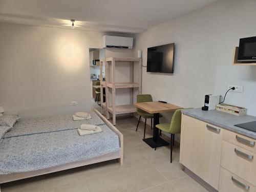 a room with a bed and a desk and a kitchen at Razor Vista Apartment in Tolmin