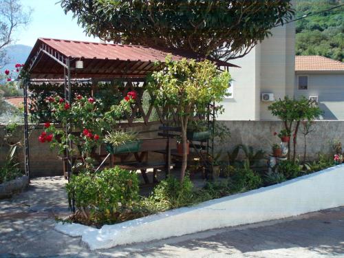a gazebo with a table and some flowers at M Group studio in Tivat