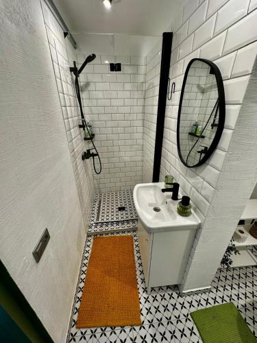a white bathroom with a sink and a mirror at Four Seasons Apartments in Tukums