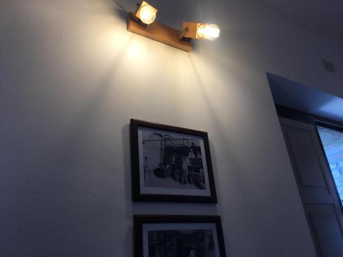 a wall with two pictures and a light on it at Agriturismo Tenuta Badia in Paciano