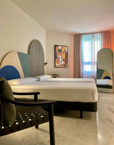a bedroom with a large bed and a chair at Onix Fira in Barcelona