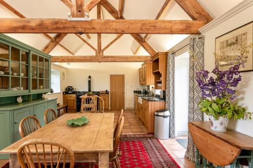 a kitchen with a wooden table and a dining room at Priory Courtyard - 3 Bedroom Countryside Escape 