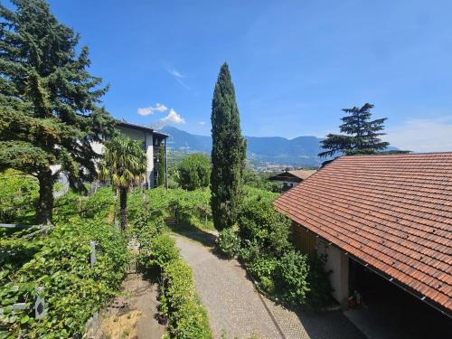 a house with a red roof and trees and a pathway at Unterdornerhof Algund in Lagundo